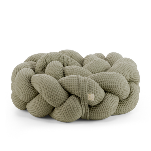 Τριπλή πάντα πλεξούδα σε χακί χρώμα από βαμβακερό ύφασμα waffle, με χειροποίητη λεπτομέρεια και ετικέτα Hebe Home – ιδανική για βρεφικό κρεβάτι.