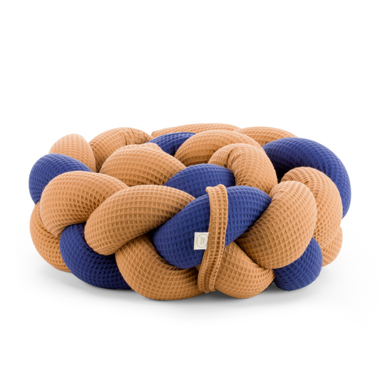 Τριπλή πάντα πλεξούδα σε κάμελ / μπλέ χρώμα από βαμβακερό ύφασμα waffle, με χειροποίητη λεπτομέρεια και ετικέτα Hebe Home – ιδανική για βρεφικό κρεβάτι.