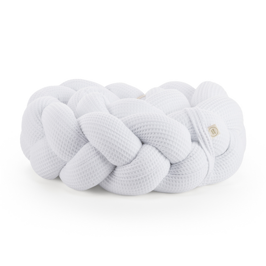 Τριπλή πάντα πλεξούδα σε λευκό χρώμα από βαμβακερό ύφασμα waffle, με χειροποίητη λεπτομέρεια και ετικέτα Hebe Home – ιδανική για βρεφικό κρεβάτι.