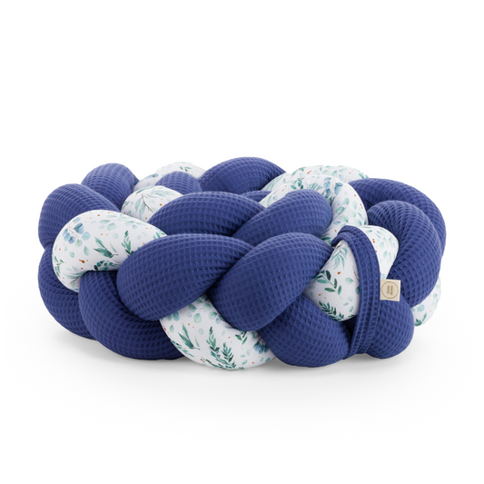 Τριπλή πάντα πλεξούδα σε blue / floral χρώμα από βαμβακερό ύφασμα waffle, με χειροποίητη λεπτομέρεια και ετικέτα Hebe Home – ιδανική για βρεφικό κρεβάτι.