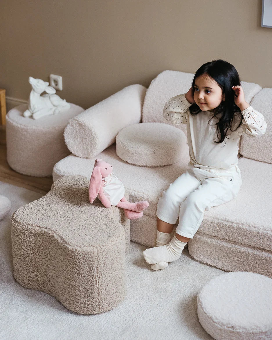 Happy girl sitting on Cream White Play Sofa made by Wigiwama