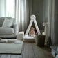 Child reading inside a small fort made with the Wigiwama Cream White Settee in a calm living room.