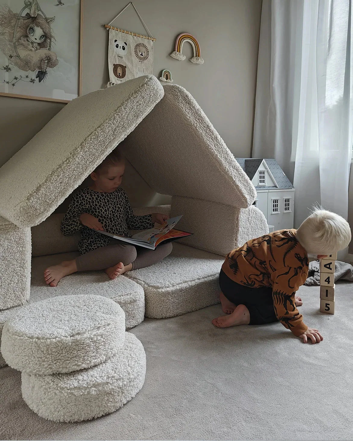 Kids playing and reading inside a fort made from the Wigiwama Cream White Settee and pouffe.