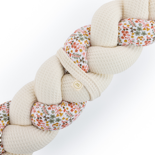 Τριπλή πάντα πλεξούδα σε cream / floral χρώμα από βαμβακερό ύφασμα waffle, με χειροποίητη λεπτομέρεια και ετικέτα Hebe Home – ιδανική για βρεφικό κρεβάτι.